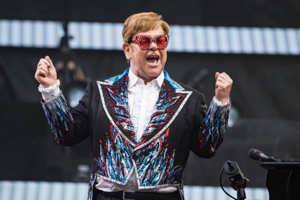 Elton John, na imagem feliz e comemorando em performance, é o novo EGOT.