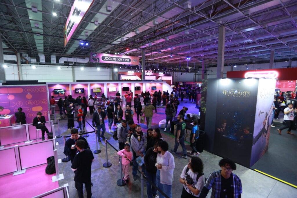Participantes entusiasmados conferem as novidades no estande de abertura em um evento de games.