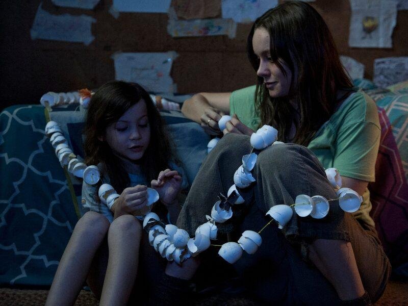 Jacob Tremblay e Brie Larson sentados no chão em cena de O quarto de Jack, um dos filmes inspirados em livros de suspense.
