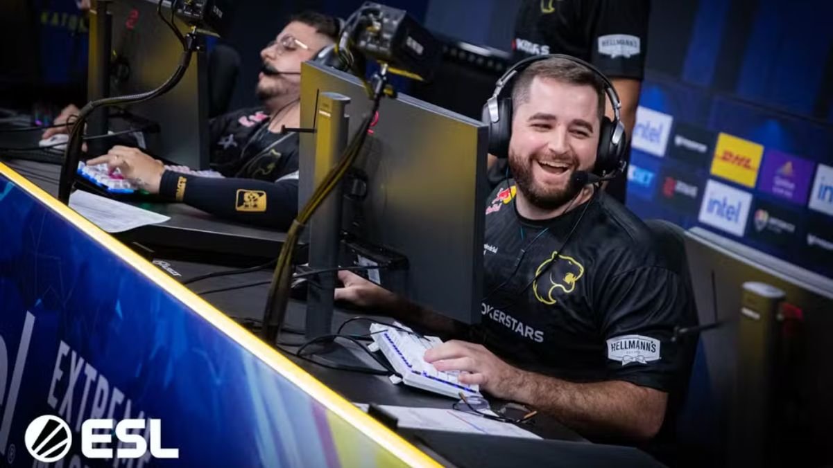 Jogadores da FURIA celebrando vitória em frente aos computadores no IEM Katowice 2025, garantindo sua classificação para a fase de grupos