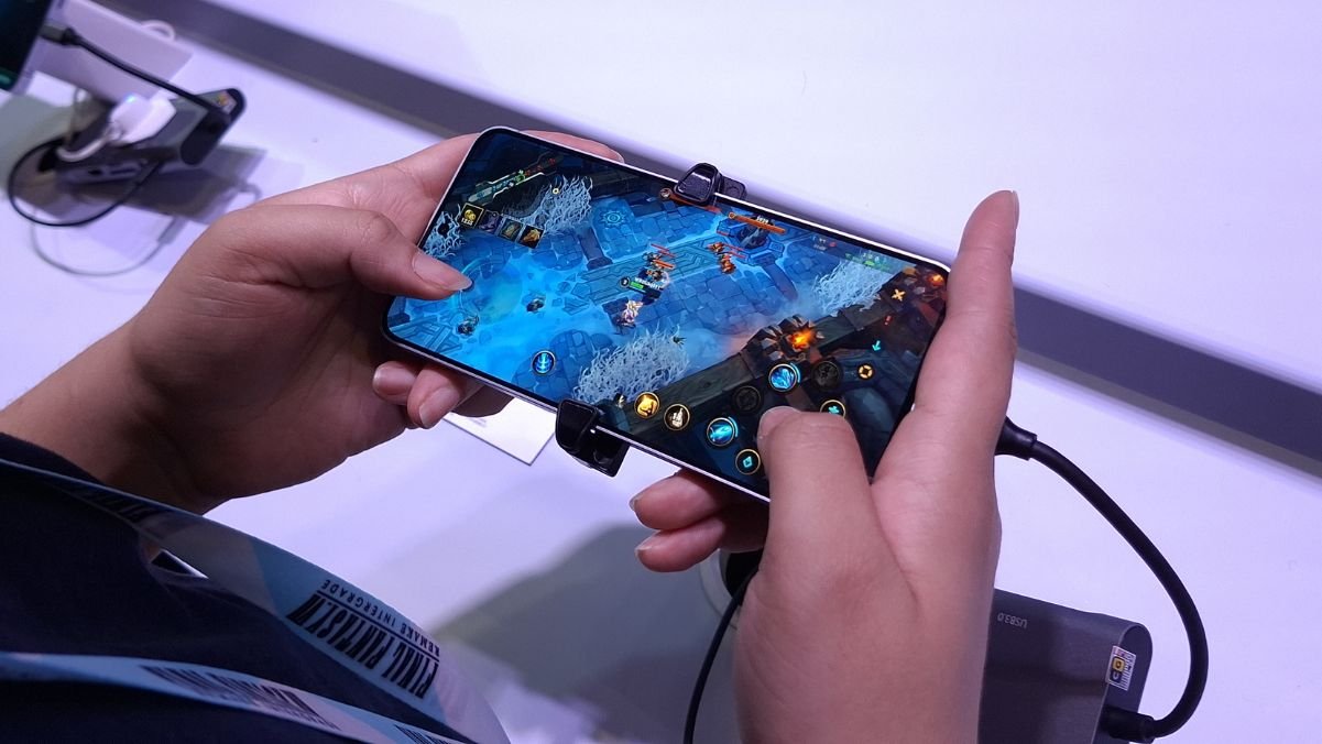 Jogador testa Wild Rift em smartphone no estande da Samsung, na BGS 2025