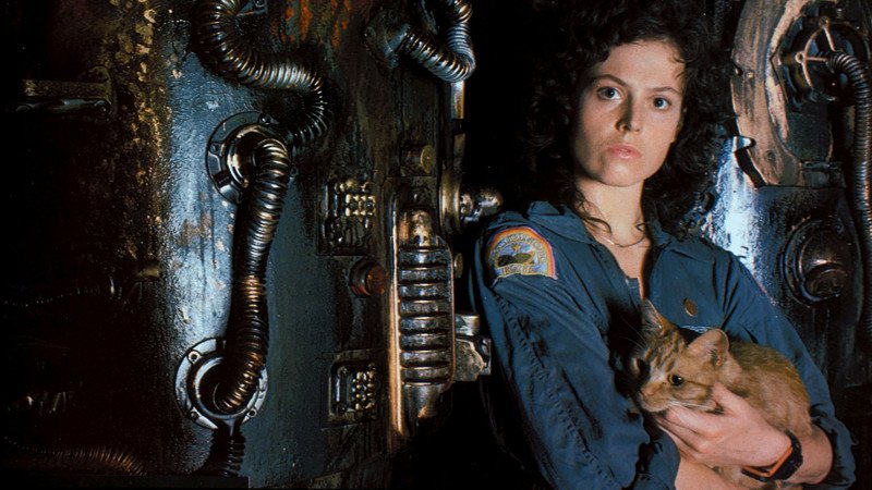 Sigourney Weaver com um gato nos braços em meio a painéis industriais escuros, em uma das cenas mais emblemáticas do gênero de ficção científica e terror.