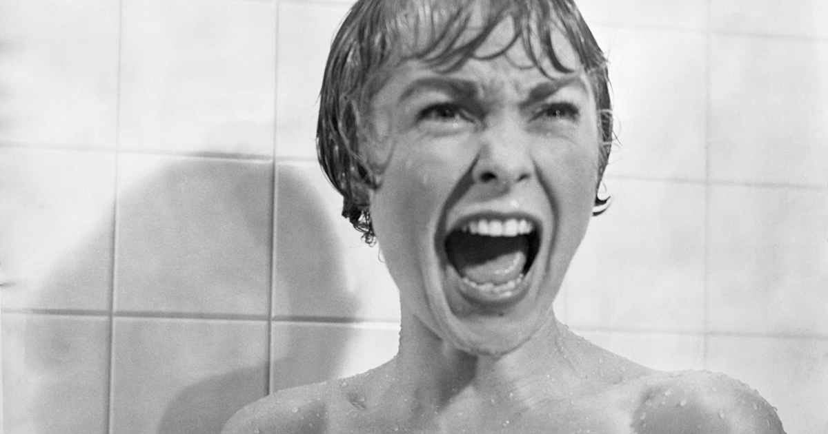 Cena em preto e branco de Janet Leigh gritando no chuveiro, umas das cenas mais icônicas adaptações de terror